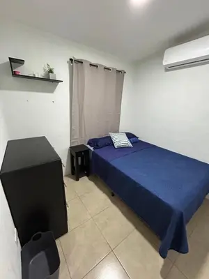 a bedroom with a blue bed and a television at Casa maea loma alta in Sonzacate