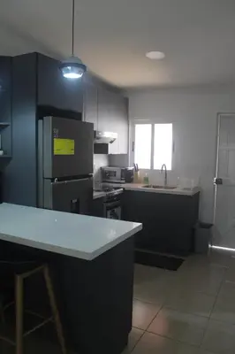a kitchen with black cabinets and a white counter top at Casa maea loma alta in Sonzacate