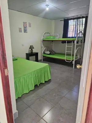 a room with two bunk beds and a green bed at Honey Beach House in La Esmeralda