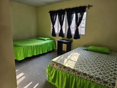 a room with two beds and a window at Honey Beach House in La Esmeralda