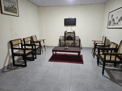 a room with chairs and a table and a tv at Honey Beach House in La Esmeralda