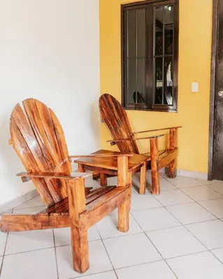 two wooden chairs sitting in a room with a window at Papaya Lodge in La Libertad