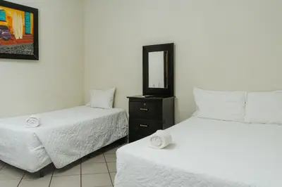 a bedroom with two beds and a mirror at Papaya Lodge in La Libertad