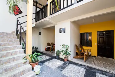 a house with a staircase and plants in front of it at Papaya Lodge in La Libertad