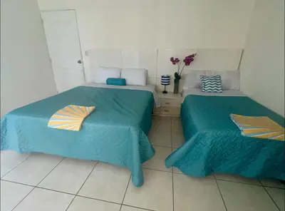 a room with two beds with blue sheets and flowers at House in Costa del Sol with beach access 5 bedrooms in Marcelino