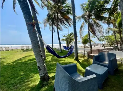a hammock hanging from two palm trees next to a beach at House in Costa del Sol with beach access 5 bedrooms in Marcelino