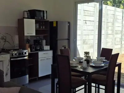 a kitchen with a table with chairs and a refrigerator at Casa Chaparrastique in San Miguel