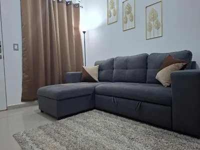 a blue couch in a living room with a rug at Casa Chaparrastique in San Miguel
