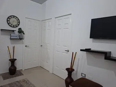a room with two white doors and a clock on a wall at Casa Chaparrastique in San Miguel