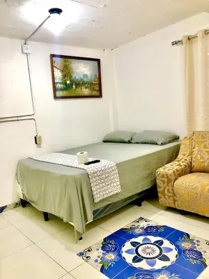 a bedroom with a bed and a table and a chair at Hostal Los planes de Renderos