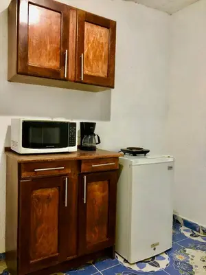a kitchen with a microwave and a small refrigerator at Hostal Los planes de Renderos