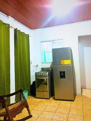 a kitchen with a refrigerator and an oven in a room at Hostal Los planes de Renderos