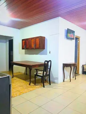 a dining room with a wooden table and a chair at Hostal Los planes de Renderos