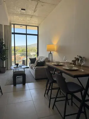 a living room with a table and a couch at Apartamento en la mejor zona - San Benito ARTHAUS in San Salvador