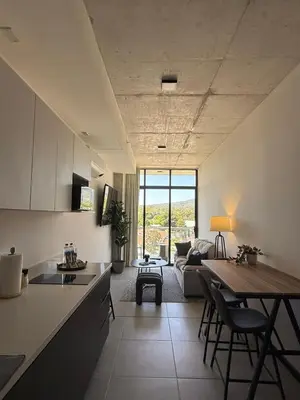 a kitchen and living room with a couch and a table at Apartamento en la mejor zona - San Benito ARTHAUS in San Salvador