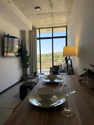 a living room with a table with two dishes on it at Apartamento en la mejor zona - San Benito ARTHAUS in San Salvador