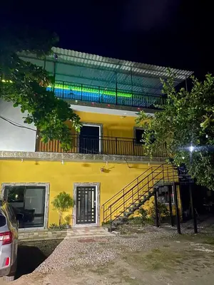 a yellow house with a staircase in front of it at Evolution Home Habitacion a 4 min del Aeropuerto Internacional ES in Las Flores