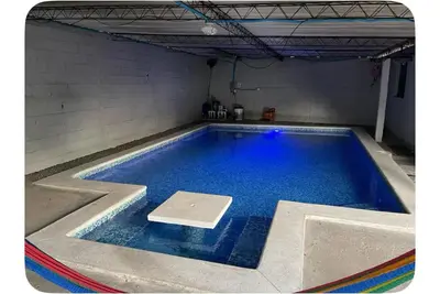 a large swimming pool with blue water in a room at Evolution Home Habitacion a 4 min del Aeropuerto Internacional ES in Las Flores