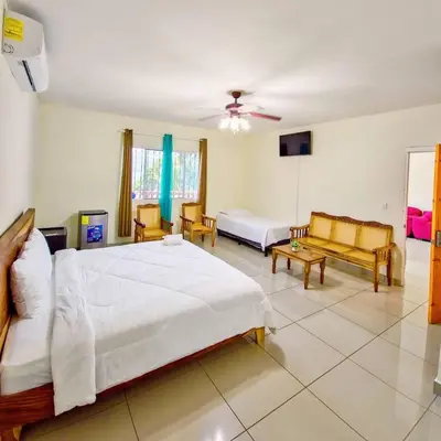 a bedroom with a large white bed and a couch at Hotel y restaurante el faro resort in San Salvador
