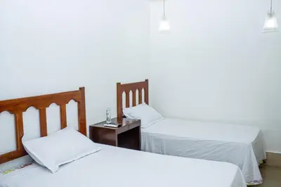 a room with two beds and a table with a nightstand at Hotel Pablo Tesák in San Vicente