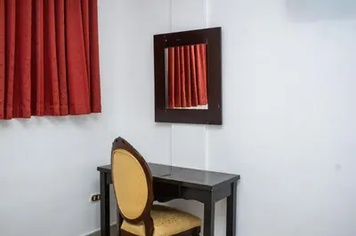 a desk with a chair and a red curtain at Hotel Pablo Tesák in San Vicente