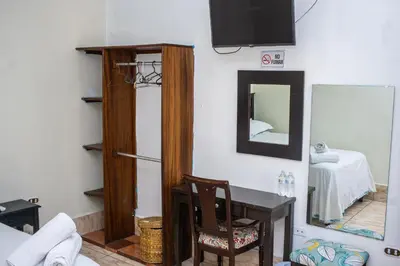 a room with a table and a mirror and a desk at Hotel Pablo Tesák in San Vicente