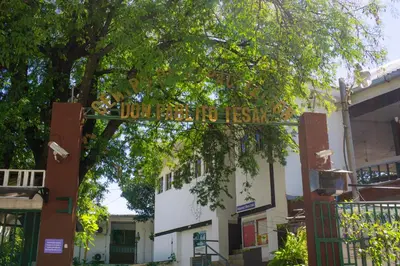 a sign in front of a building with a tree at Hotel Pablo Tesák in San Vicente
