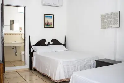 a bedroom with a bed and a bathroom with a sink at Hotel Pablo Tesák in San Vicente