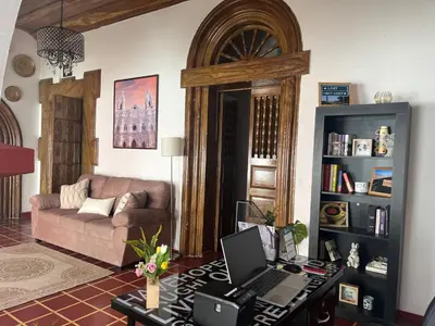 a living room with a couch and a desk with a laptop at Club 27 - Hostal, Cafe & Spa in Santa Ana