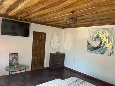 a bedroom with a bed and a tv and a table at Club 27 - Hostal, Cafe & Spa in Santa Ana