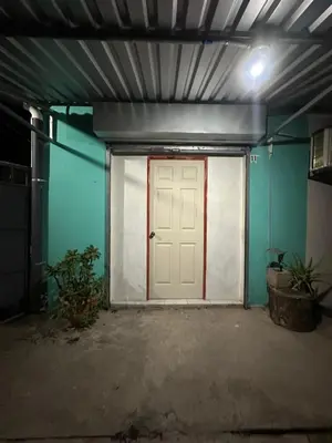 a garage with a white door and blue walls at Hostal las brisas in El Rosario