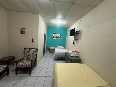 a hospital room with two beds and a chair at Hostal las brisas in El Rosario