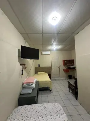 a room with two beds and a flat screen tv at Hostal las brisas in El Rosario