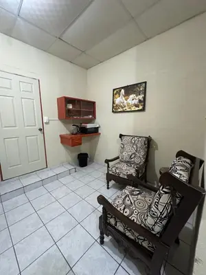 a living room with two chairs and a door at Hostal las brisas in El Rosario