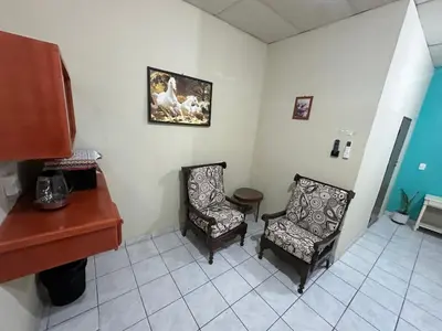 a room with two chairs and a desk and a piano at Hostal las brisas in El Rosario