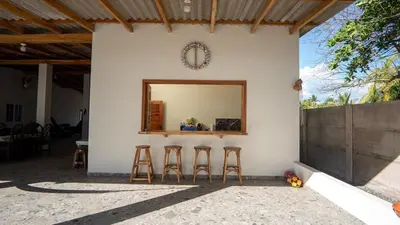 a mirror on the side of a white wall with stools at Ranch Pacific Dreams Home in Playa Cangrejeras