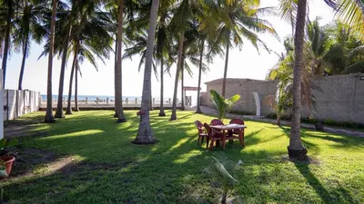 a table and chairs in a lawn with palm trees at Ranch Pacific Dreams Home in Playa Cangrejeras