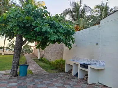 a white bench next to a wall with a tree at Ranch Pacific Dreams Home in Playa Cangrejeras