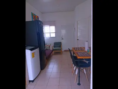 a kitchen with a table and a refrigerator at Casa de Milo in Ahuachapán