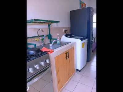 a kitchen with a sink and a stove and a refrigerator at Casa de Milo in Ahuachapán