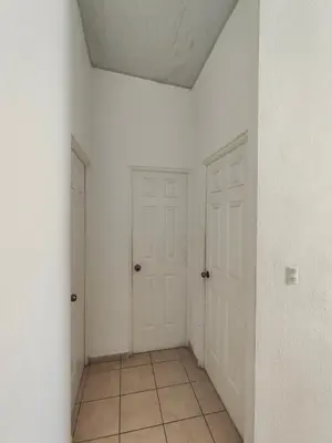 an empty room with two white doors and a tile floor at La casa de Alex in San Juan Opico