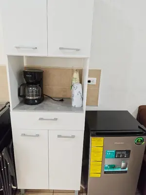 a kitchen with a white cabinet and a microwave at La casa de Alex in San Juan Opico