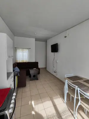 a living room with a couch and a tv on the wall at La casa de Alex in San Juan Opico