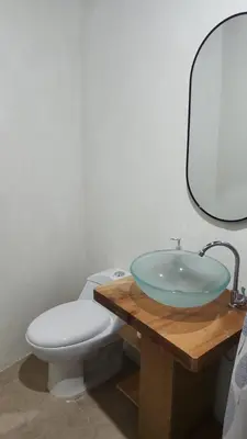 a bathroom with a sink and a toilet at Cabañas y Café Kauani