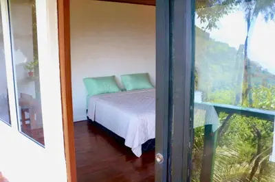 a bedroom with a bed with a view of a balcony at Cabañas y Café Kauani