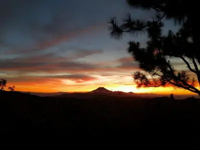 a sunset with a mountain in the background at Cabañas y Café Kauani