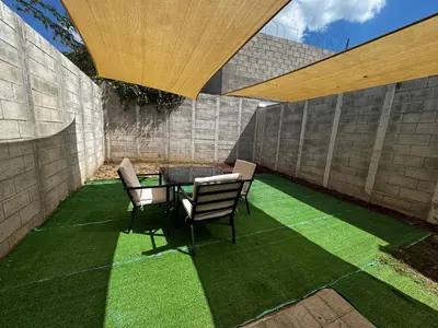 a patio with a table and chairs on grass at La Santanita in Santa Ana