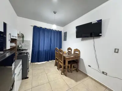 a kitchen with a table and chairs and a television on the wall at La Santanita in Santa Ana
