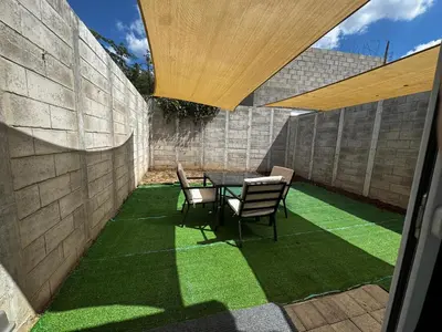 a patio with a table and chairs on artificial grass at La Santanita in Santa Ana