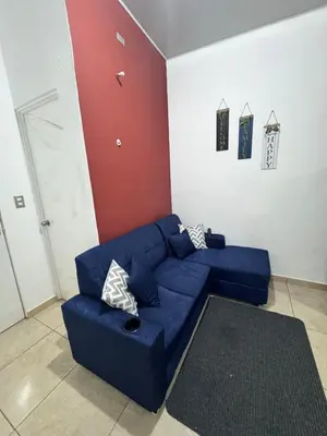 a living room with a blue couch and a red wall at La Santanita in Santa Ana